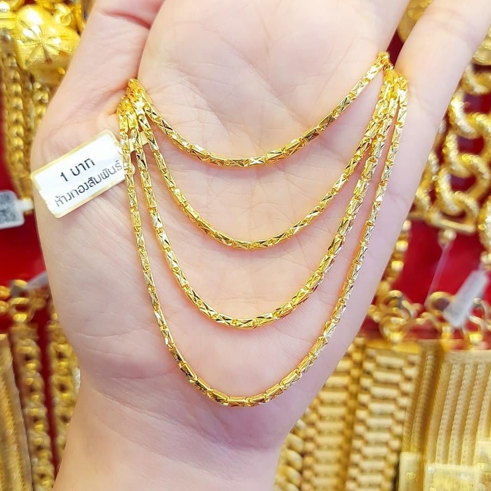 Close-up of an exposed 23K Gold Chain (1 Baht) held in a hand, emphasizing the deep yellow color and fine craftsmanship.