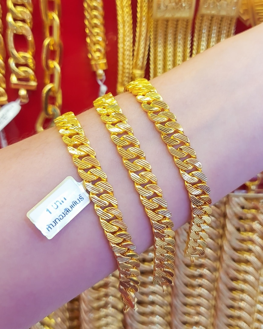 Close-up of a substantial 23K Gold Bracelet (1 Baht weight) featuring a wide, interlocking braided link design.
